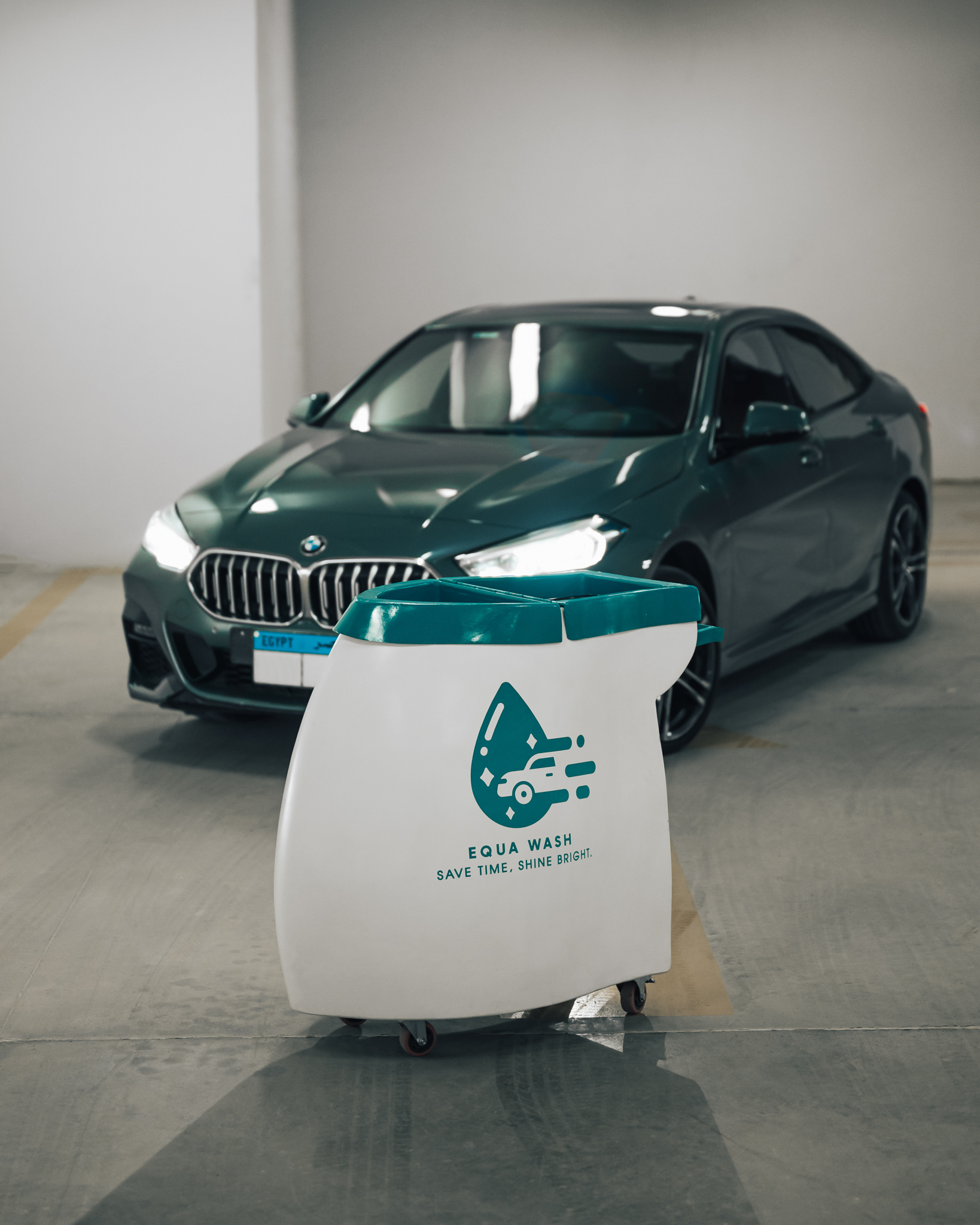 Equa Wash cart beside a BMW in an indoor commercial garage