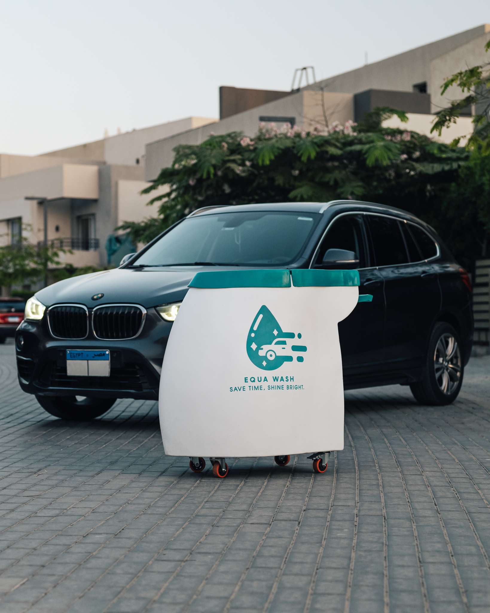 Equa Wash cart beside a BMW X1 in a gated compound with villas