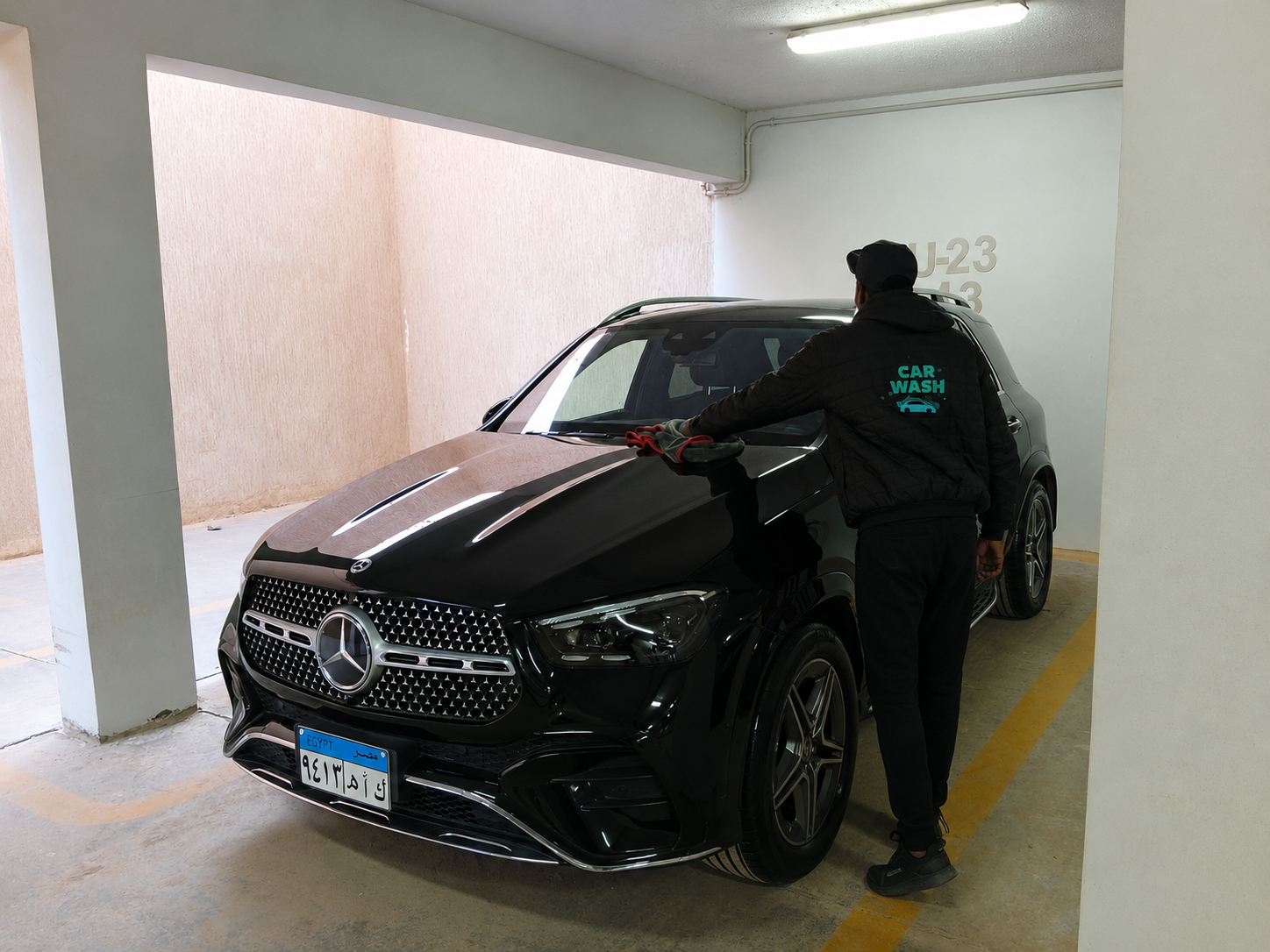 Equa Wash professional servicing a black Mercedes GLE underground