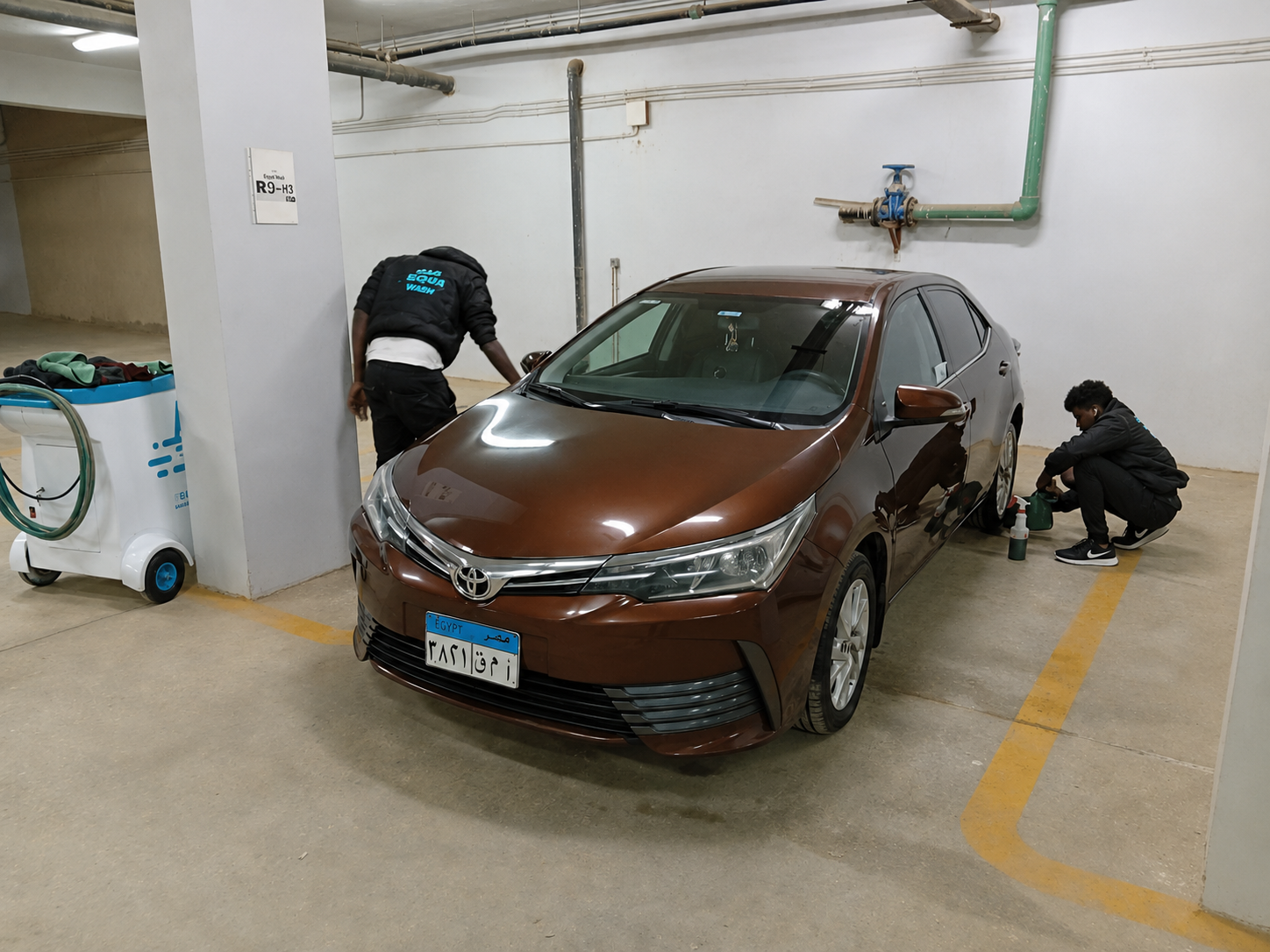 Two Equa Wash team members servicing a Toyota Corolla underground